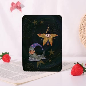 May include: A rectangular e-reader case featuring a dark green background with swirling lines and stars. The illustration depicts a character wearing a star-patterned witch hat and a crescent moon character with a purple nightcap and closed eyes.