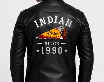 Może przedstawiać: Czarna skórzana kurtka z grafiką na plecach zawierającą napis INDIAN, kolorową ilustrację osoby w pióropuszu, słowo Indian, napis SINCE oraz rok 1990 otoczony dwiema gwiazdkami, wykonane białymi literami.
