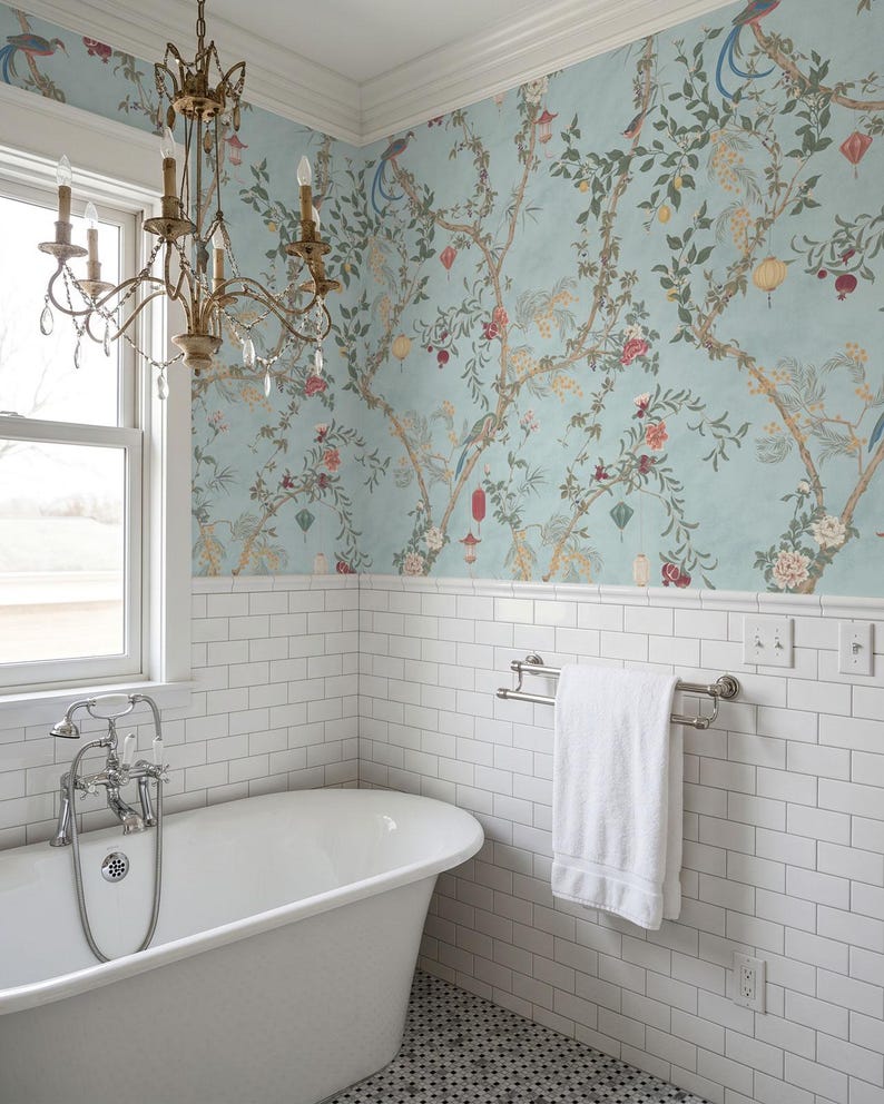 May include: A bathroom with a clawfoot tub, white subway tile, and a floral wallpaper in shades of blue, green, and red. A brass chandelier hangs above the tub, and a white towel hangs on a chrome towel rack.