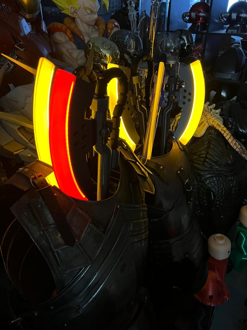 Op de afbeelding: Een verzameling gedetailleerde, donkergekleurde fantasy-pantserstukken en wapens. Het pantser heeft een metallic uitstraling met ingewikkelde ontwerpen. Sommige stukken hebben gloeiende gele en rode accenten, wat een opvallend visueel contrast cre&euml;ert. De items worden gepresenteerd in een zwak verlichte omgeving.