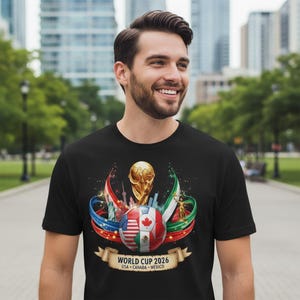 May include: Black t-shirt featuring a graphic for the 2026 World Cup. The design includes a soccer ball with flags of the USA, Canada, and Mexico, a gold trophy, and the text "WORLD CUP 2026 USA &bull; CANADA &bull; MEXICO".