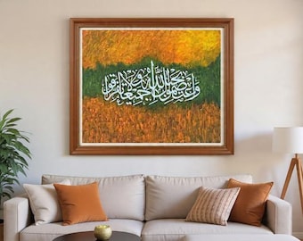 May include: A framed abstract painting with Arabic calligraphy in white against a backdrop of orange, green, and yellow hues. The artwork is displayed above a beige sofa with orange and patterned throw pillows. A lamp and a potted plant are also visible.