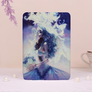 May include: A rectangular case featuring a digital illustration of a bride with blue skin, curly blue hair, and a white veil. She is holding a bouquet of blue flowers and wearing a blue dress. The background is a gradient of purple and blue.