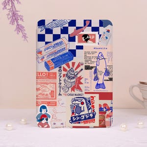 May include: A decorative rectangular item with a collage of vintage-style graphics. The design includes a blue and white checkered pattern, fish illustrations, Japanese text, and a box of "Juicy Fresh" gum. The color palette is primarily red, blue, and white.