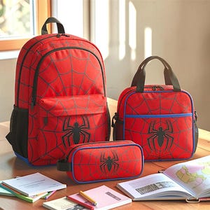 A Spiderman-themed backpack and two lunch bags are placed on a wooden table, along with some books and a map.