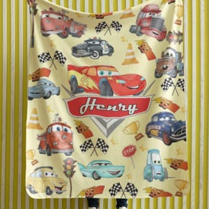 Peut inclure: Une couverture jaune clair avec des illustrations de voitures de dessins anim&eacute;s, des drapeaux &agrave; damiers et des troph&eacute;es. Le nom "Henry" est affich&eacute; dans une banni&egrave;re rouge. La couverture pr&eacute;sente un motif r&eacute;p&eacute;t&eacute; de voitures de course et d'autres v&eacute;hicules.