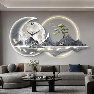 Op de afbeelding: Een grote wandklok met een ontwerp van een halve maan en een cirkel met geïntegreerde ledverlichting. De wijzerplaat toont een berglandschap met een boom, herten en zwemmende vissen. De cijfers 3, 6, 9 en 12 zijn duidelijk zichtbaar.