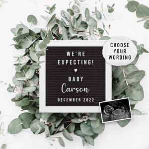 May include: A black letter board with white letters announcing "We're expecting! Baby Carson December 2022". The board is surrounded by eucalyptus leaves and a white background. A black and white ultrasound image is in the bottom right corner.