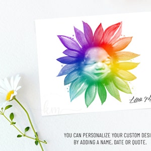 Pu&ograve; includere: Un girasole ad acquerello arcobaleno con il viso di un bambino al centro. Il girasole &egrave; su uno sfondo bianco con il nome "Lilith Mae" scritto in corsivo nero.
