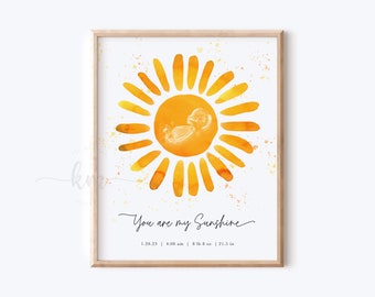 May include: Watercolor art print in a wooden frame. The artwork features a yellow and orange sun with a baby's sonogram in the center. Text reads "You are my Sunshine" with date, time, weight (8 lbs 8 oz), and height (21.5 in).