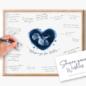 Puede incluir: Una impresión enmarcada con un corazón de acuarela que contiene una ecografía de bebé. El texto "Blessings for Billy" está escrito en cursiva. Una tarjeta con "Share your Wishes" está al lado del marco. El marco es marrón claro.