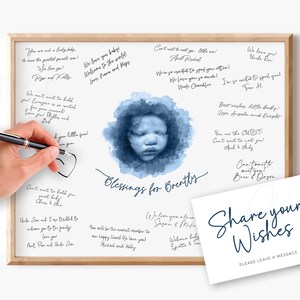Puede incluir: Una impresión enmarcada con una imagen de acuarela de la cara de un bebé, rodeada de tonos azules. Las palabras "Blessings for Brently" están escritas debajo. Una tarjeta con "Share your Wishes" está a la derecha.