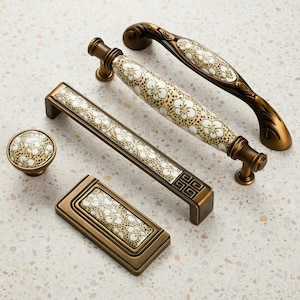 May include: A selection of antique bronze cabinet hardware, including handles, a knob, and a rectangular pull. Each piece features a cream ceramic insert with a floral pattern. The hardware is designed for furniture and cabinetry.