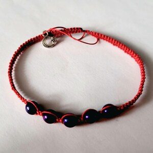 Puede incluir: Pulsera de macramé roja con cinco cuentas azul oscuro y un dije plateado con un diseño de luna creciente y estrella. La pulsera tiene un cierre de nudo corredizo para un ajuste ajustable.