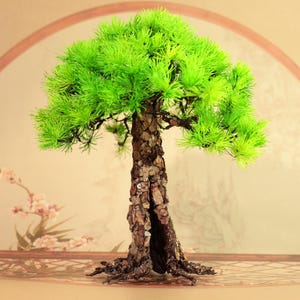 Puede incluir: Un árbol bonsái en miniatura con follaje verde vibrante y un tronco marrón texturizado. El árbol se encuentra sobre un fondo suave y neutro con un arco decorativo y acentos florales, creando una estética serena y natural.
