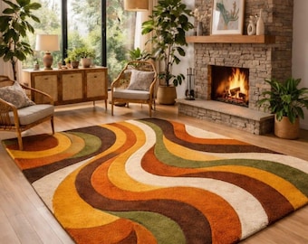 May include: A retro-style area rug with a wavy pattern in shades of orange, brown, green, and cream. The rug is placed in a living room with a fireplace, wicker chairs, and large windows. The rug's design evokes a 1970s aesthetic.