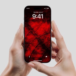 Könnte beinhalten: Ein Smartphone, das in zwei Händen gehalten wird und ein rotes und schwarzes abstraktes Design auf dem Bildschirm zeigt. Die Uhrzeit ist 9:41 Uhr und das Datum ist Montag, der 6. Juni. Das Telefon hat einen schwarzen Rand und einen silbernen Rahmen.