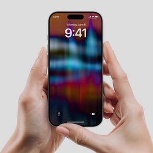 Könnte beinhalten: Ein schwarzes Smartphone mit einem farbenfrohen, abstrakten Hintergrund wird von zwei Händen gehalten. Der Bildschirm zeigt die Uhrzeit 9:41 Uhr am Montag, 6. Juni an. Das Telefon hat eine Kerbe oben und einen dünnen Rahmen.