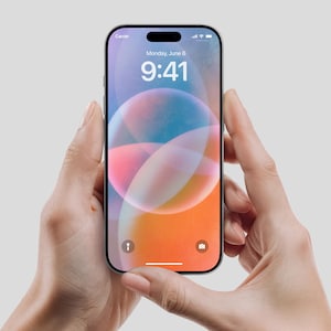 Könnte beinhalten: Ein schwarzes Smartphone mit einem farbenfrohen, abstrakten Hintergrundbild wird von zwei Händen gehalten. Der Bildschirm zeigt das Datum, Montag, 6. Juni, und die Uhrzeit 9:41 Uhr an. Das Telefon hat einen schwarzen Rahmen und eine Kerbe oben.