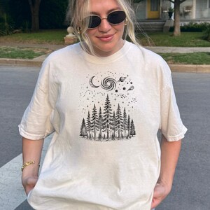 May include: A set of three ceramic mugs with a speckled, matte finish. The mugs are in shades of cream, light gray, and dark gray. Each mug has a simple, minimalist design, perfect for coffee or tea.