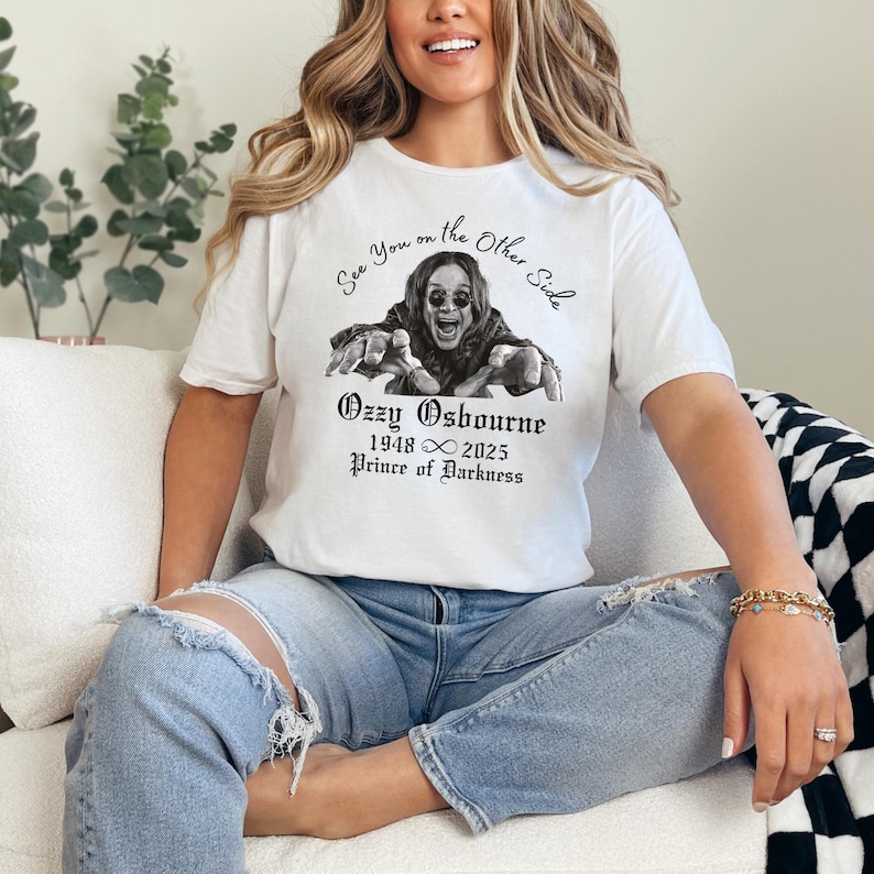 Może przedstawiać: Biała koszulka z czarno-białą grafiką Ozzy'ego Osbourne'a i napisem "See You on the Other Side". Pod grafiką znajduje się napis "Ozzy Osbourne 1948 &infin; 2025 Prince of Darkness."