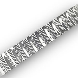 Puede incluir: Una barra metálica rectangular con un patrón de acero de Damasco de alto contraste, con líneas onduladas alternas en negro y plata que corren verticalmente a lo largo de su longitud. La superficie presenta un acabado pulido.