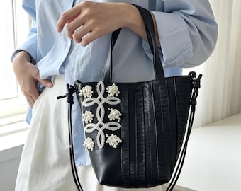 Emmerhandtas van gestructureerd imitatieleer met zeeanemoonborduurwerk, om te dragen als crossbodytas (met magneetsluiting).