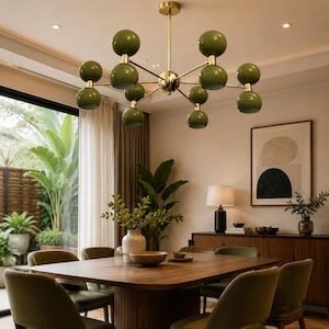May include: A multi-arm chandelier featuring a central gold-toned metal rod and branching arms that support ten spherical olive green shades arranged in pairs. The fixture is suspended from the ceiling, providing overhead illumination to the room.