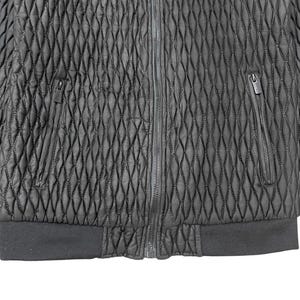 Puede incluir: Chaqueta negra acolchada con un patr&oacute;n de diamantes. Cuenta con cremallera completa, dos bolsillos con cremallera y dobladillo y pu&ntilde;os de canal&eacute;. La chaqueta est&aacute; hecha de un material texturizado.