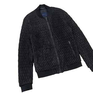 Puede incluir: Chaqueta bomber acolchada negra con cierre de cremallera completo, dos bolsillos delanteros y pu&ntilde;os y dobladillo de canal&eacute;. La chaqueta tiene un patr&oacute;n de diamantes texturizado y un cuello bomber cl&aacute;sico.