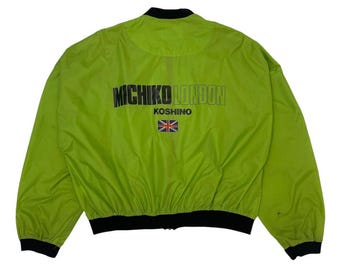 May include: A neon green bomber jacket with black trim and a zipper closure. The back of the jacket features the text "MICHIKO LONDON" above "KOSHINO" and a Union Jack flag.