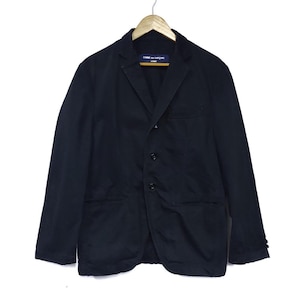 May include: A black blazer with a notched lapel, three-button closure, and two front pockets. The jacket is hanging on a wooden hanger. The label reads "COMME des GARCONS HOMME".