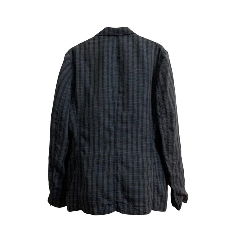 May include: A dark gray blazer with a plaid pattern. The jacket has long sleeves and a notched lapel. The back of the blazer is visible, showing the tailored fit and the fabric's texture. The color scheme is primarily dark gray and black.