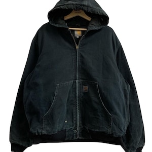 May include: A black hooded jacket with a zipper closure, two front pockets, and a ribbed hem and cuffs. The jacket has a worn appearance and a Carhartt label. The hood is attached and has a distressed area.