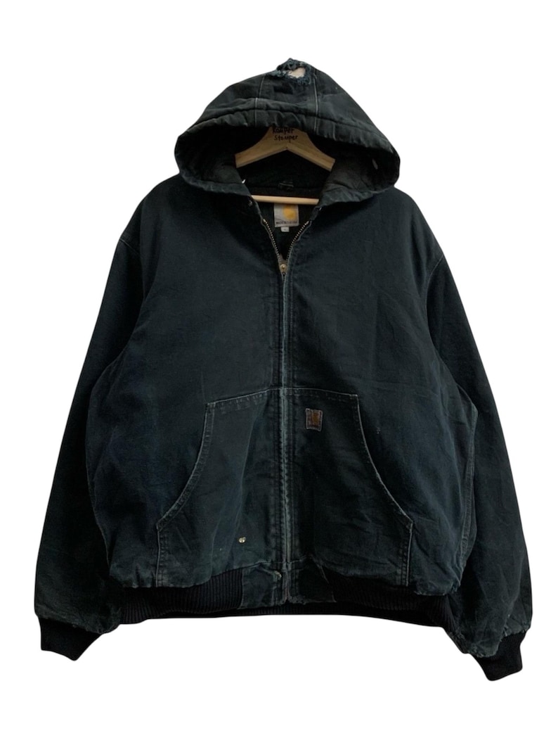 May include: A black hooded jacket with a zipper closure, two front pockets, and a ribbed hem and cuffs. The jacket has a worn appearance and a Carhartt label. The hood is attached and has a distressed area.