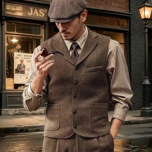 Könnte beinhalten: Eine braune Tweed-Weste mit steigendem Revers, vier Knöpfen und zwei Vordertaschen, getragen über einem beigefarbenen und braun karierten Langarmhemd mit dunkler Krawatte. Dazu eine braune Schiebermütze und eine dunkelbraune Tabakpfeife in der Hand.