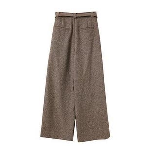 May include: High-waisted wide-leg trousers in a textured brown fabric. These pants feature a matching belt with a buckle at the waist, two horizontal welt pockets on the back, and a straight, loose-fitting silhouette that extends to the hem.