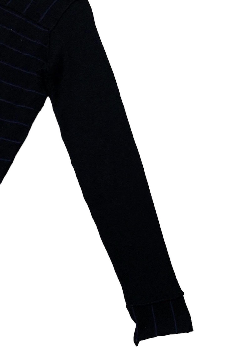 Puede incluir: Top negro de manga larga con sutiles rayas moradas. Se ve la manga, con un pu&ntilde;o acanalado. La tela parece ser un punto suave, adecuado para usar solo o en capas. El dise&ntilde;o es sencillo y vers&aacute;til.