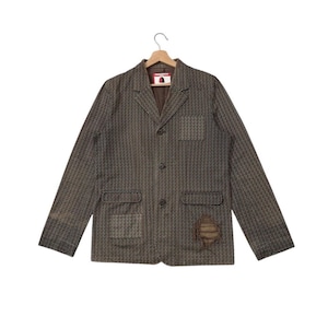 May include: Brown patterned blazer with three buttons and two front pockets. The jacket features a distressed patch on the right sleeve. It is suspended from a wooden hanger.