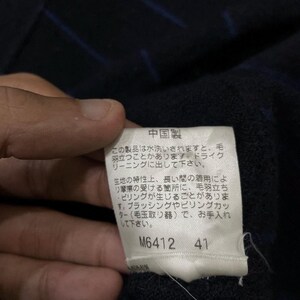 Puede incluir: Primer plano de una etiqueta con texto japon&eacute;s, adherida a una tela azul oscuro con rayas azules. La etiqueta es blanca con texto negro y los n&uacute;meros M6412 y 41.