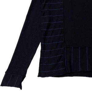 Puede incluir: Un su&eacute;ter de manga larga azul marino con un panel negro y detalles a rayas. La manga presenta un pu&ntilde;o acanalado con rayas a juego. El dise&ntilde;o del su&eacute;ter incluye patrones de rayas verticales y horizontales.