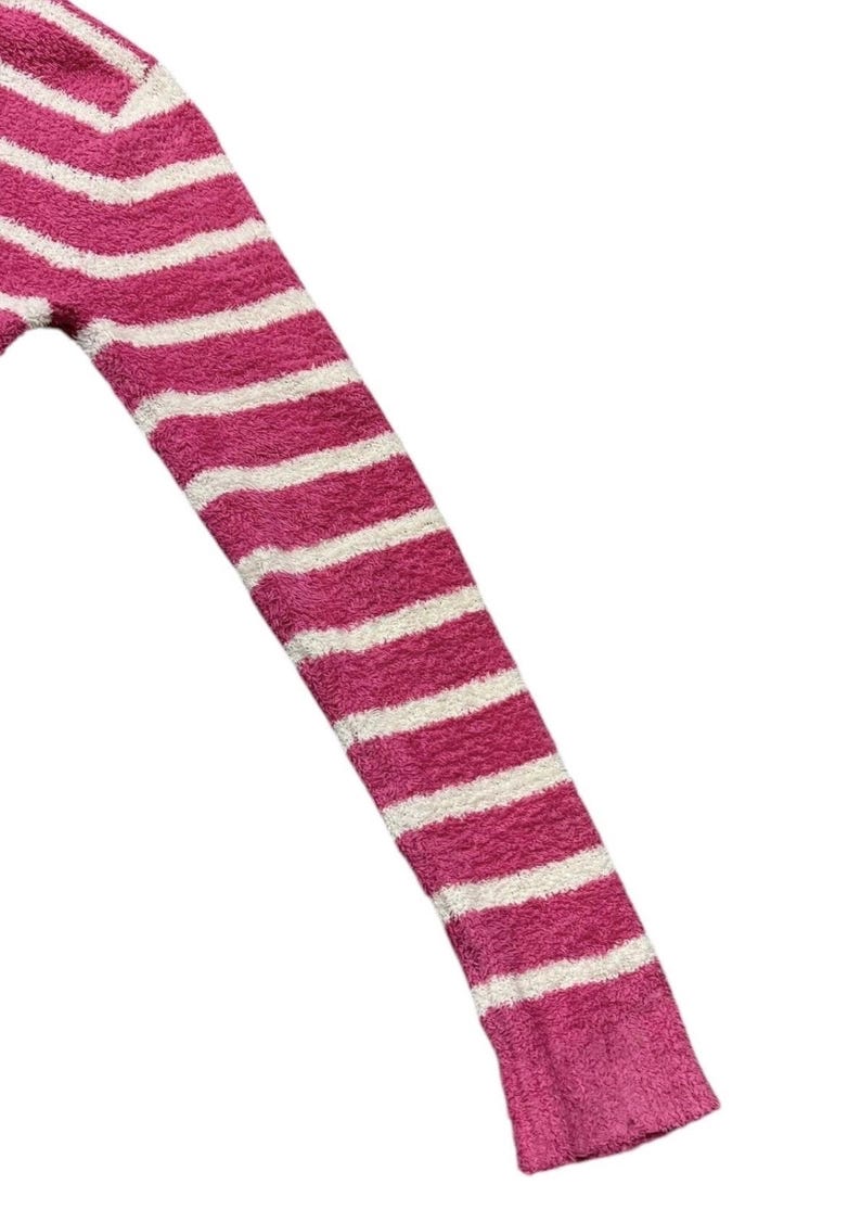 May include: Close-up of a pink and white striped sweater sleeve. The sleeve is made of a soft, fuzzy material. The stripes are horizontal and evenly spaced. The cuff of the sleeve is a solid pink color.