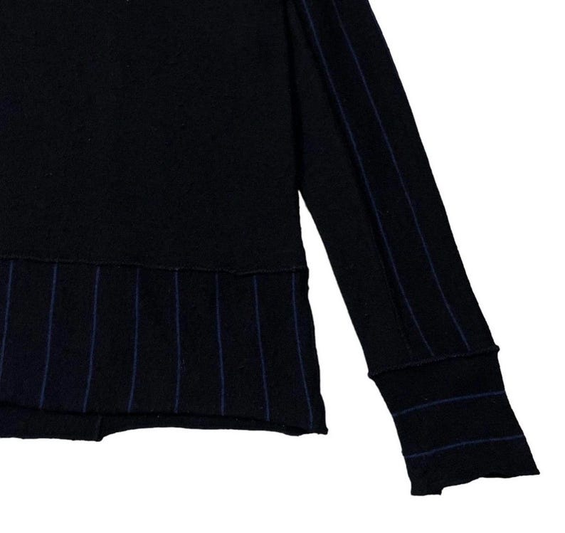 Puede incluir: Camisa negra de manga larga con finas rayas azules en el dobladillo inferior y la manga. Los pu&ntilde;os tambi&eacute;n presentan finas rayas azules. La camisa est&aacute; hecha de un material suave y c&oacute;modo.