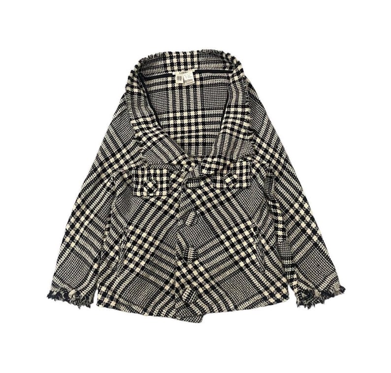 May include: A black and white plaid jacket with a shawl collar and frayed edges. The jacket features a mix of large and small plaid patterns. The garment is made of a textured fabric.