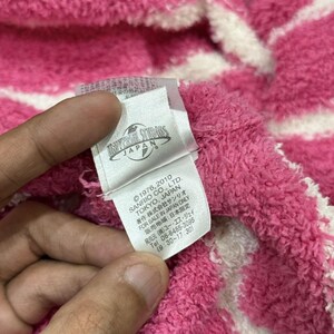 May include: Close-up of a pink and white striped fabric with a tag. The tag reads "UNIVERSAL STUDIOS JAPAN" and includes text about Sanrio Co., Ltd. and copyright information.