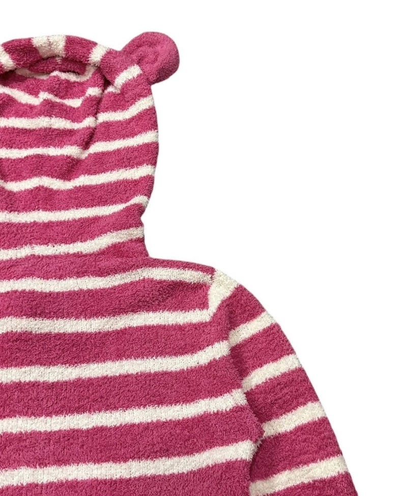 May include: A pink and white striped hooded sweatshirt with bear ears. The soft, plush fabric features horizontal stripes. The hood has two small, rounded ears at the top. The sweatshirt is a cozy, casual garment.