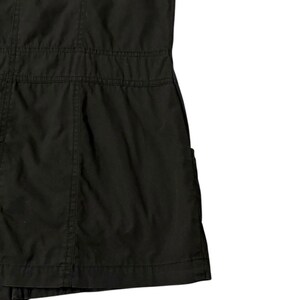 Puede incluir: Prenda negra con costuras visibles y un dise&ntilde;o estructurado. La tela parece ser un material resistente, con costuras horizontales que crean una zona de cintura definida. La prenda tiene un bolsillo lateral.