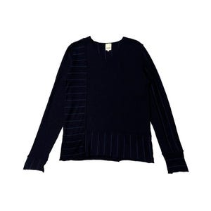 Puede incluir: Camisa de manga larga azul marino con cuello en V. La camisa presenta detalles de rayas verticales en el lado izquierdo y en la manga derecha. El dobladillo inferior tambi&eacute;n tiene detalles de rayas horizontales. Una peque&ntilde;a etiqueta est&aacute; cerca del cuello.