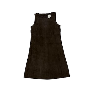 May include: A sleeveless dark brown suede dress featuring a round neckline and a straight, knee-length silhouette. The garment has a visible interior tag at the center of the neckline and vertical seam detailing running down the front panel.
