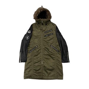 May include: An olive green winter coat with a faux fur-lined hood and black sleeves. The coat features multiple zippered pockets and a patch on the left sleeve. The coat is a long, mid-thigh length.